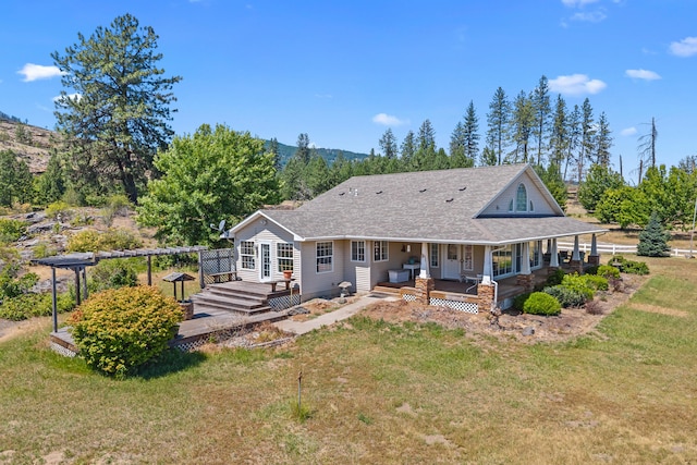 76 Kifer Rd, Kettle Falls, WA 99141 - back of property featuring a lawn, a mountain view, covered porch, and a shingled roof