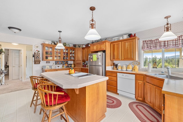 76 Kifer Rd, Kettle Falls, WA 99141 - kitchen featuring dishwasher, wallpapered walls, freestanding refrigerator, a kitchen island, and tile counters