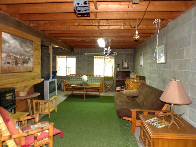 living room featuring concrete block wall and a wood stove