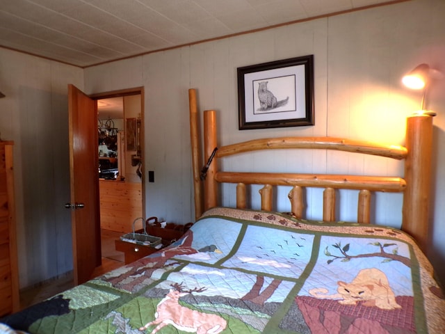 bedroom featuring wooden walls, a closet, and ornamental molding