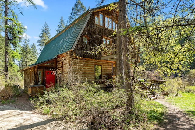 view of property exterior with a gambrel roof and metal roof
