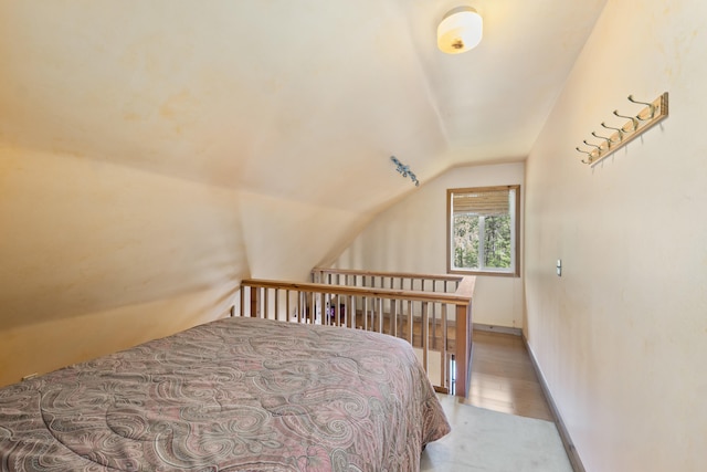 bedroom with light colored carpet and lofted ceiling