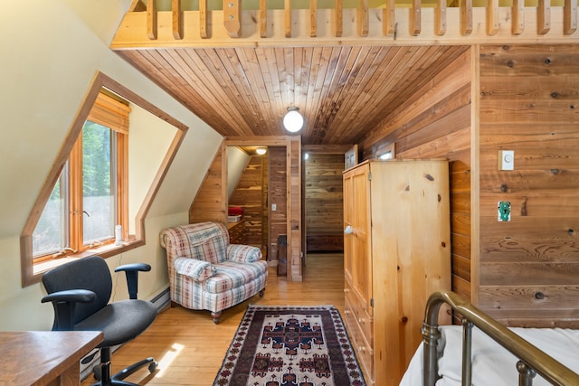 living area with a baseboard heating unit, wood walls, wooden ceiling, and light wood-style flooring