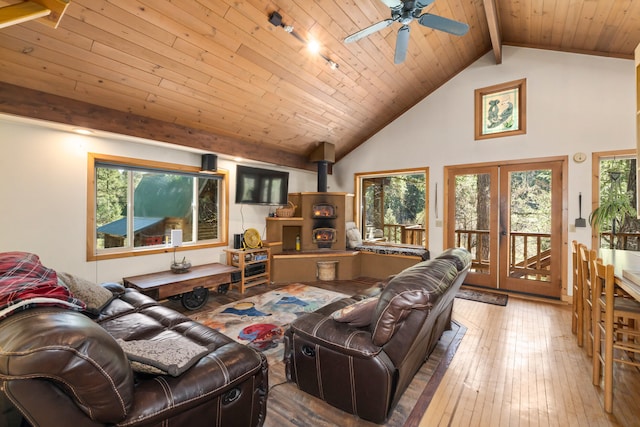 living area featuring a wood stove, beamed ceiling, high vaulted ceiling, french doors, and a ceiling fan