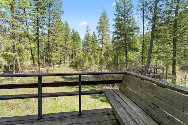 wooden terrace featuring a forest view