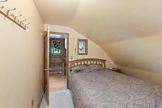 bedroom with light colored carpet and lofted ceiling