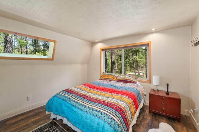 bedroom featuring baseboards, multiple windows, and wood finished floors