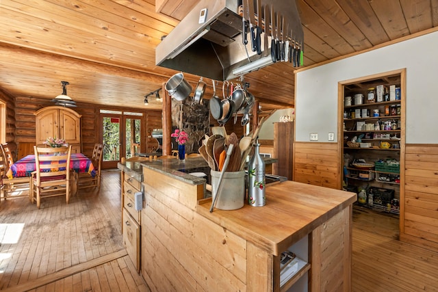 kitchen featuring log walls, wood ceiling, wainscoting, and hardwood / wood-style floors