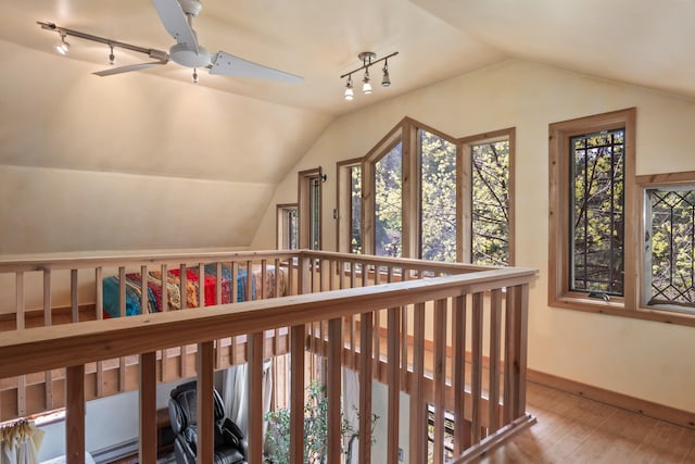 interior space featuring wood finished floors, baseboards, and lofted ceiling