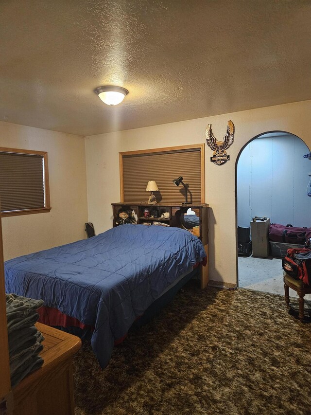 bedroom with a textured ceiling and carpet floors