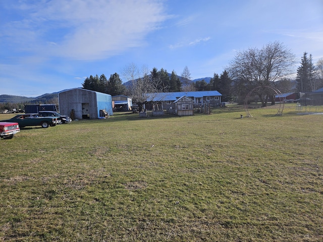 view of yard with a mountain view and an outbuilding