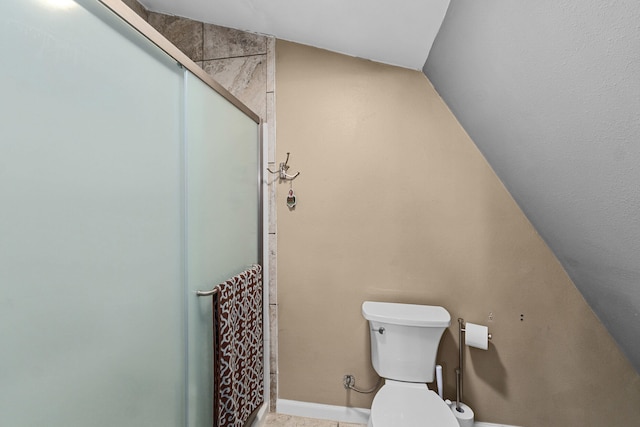 bathroom featuring vaulted ceiling, toilet, and walk in shower