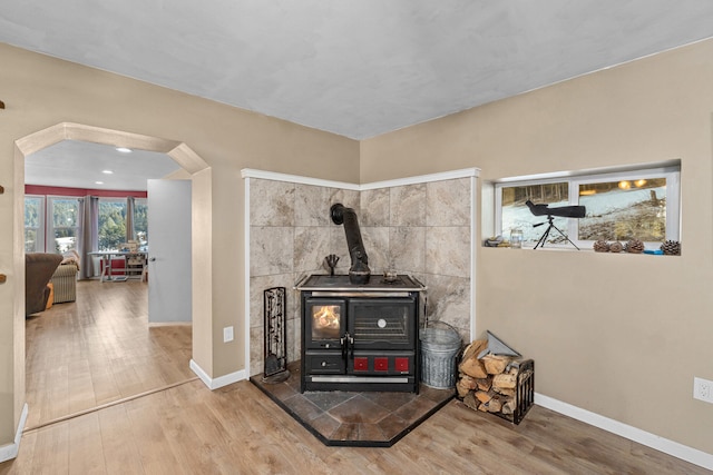 interior details with a wood stove and hardwood / wood-style flooring