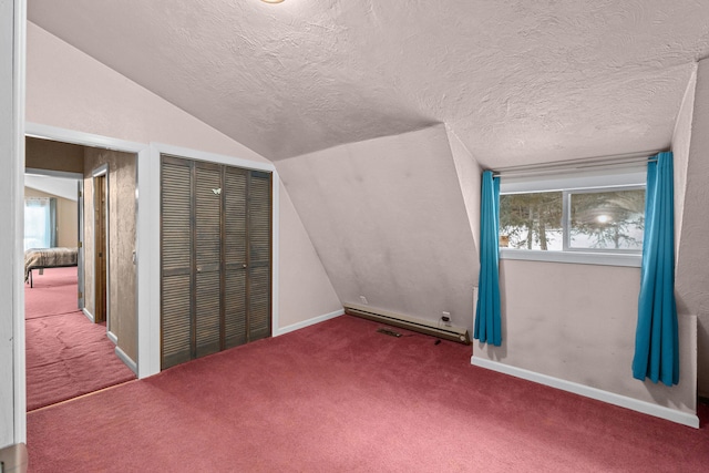 additional living space with baseboard heating, carpet flooring, vaulted ceiling, and a textured ceiling