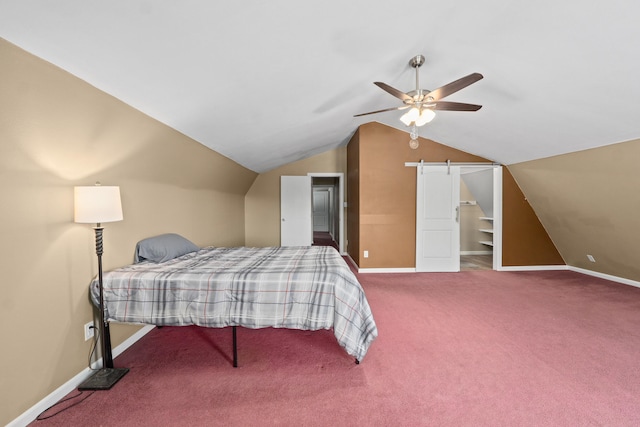 bedroom with lofted ceiling, ceiling fan, carpet flooring, and a barn door