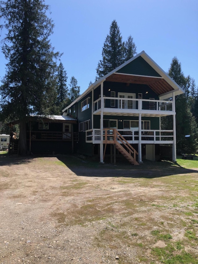 rear view of property with a wooden deck and stairway
