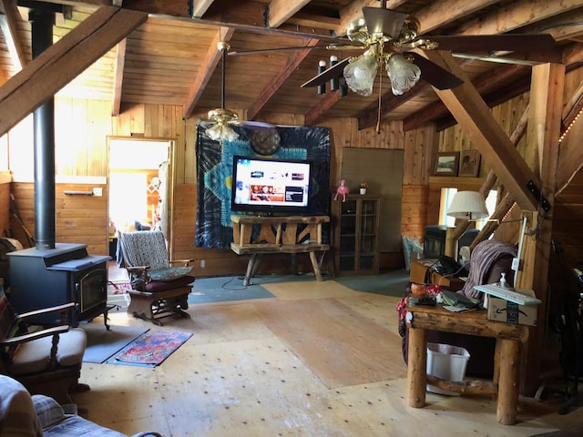 living room featuring wooden walls, wood ceiling, a wood stove, and a ceiling fan