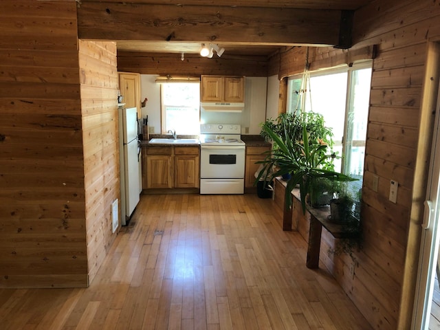 kitchen featuring beam ceiling, light wood-style floors, white appliances, wood walls, and under cabinet range hood