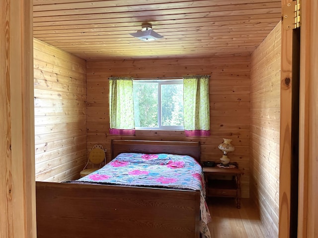 bedroom with wood walls, wood ceiling, and wood finished floors