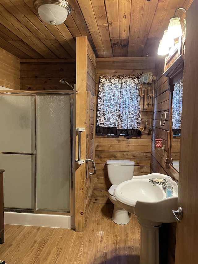 full bath with wooden walls, a shower stall, wood ceiling, and wood finished floors