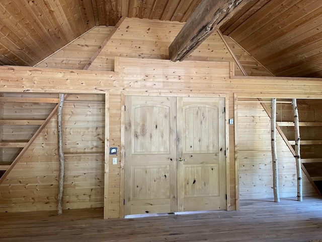 additional living space featuring wooden walls, wooden ceiling, beam ceiling, and wood finished floors