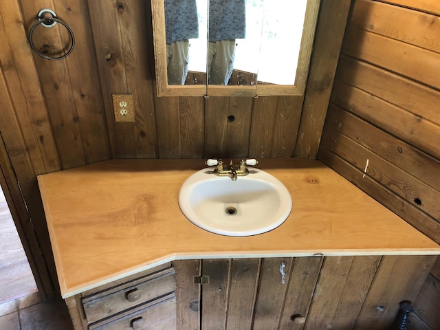 bathroom with vanity and wood walls