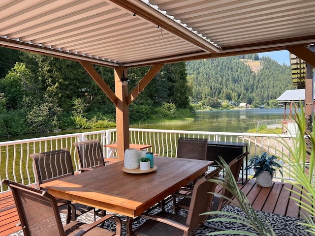 2851 Deep Lake Lopps Rd, Colville, WA 99114 - wooden deck with a lawn, outdoor dining area, a water view, and a view of trees
