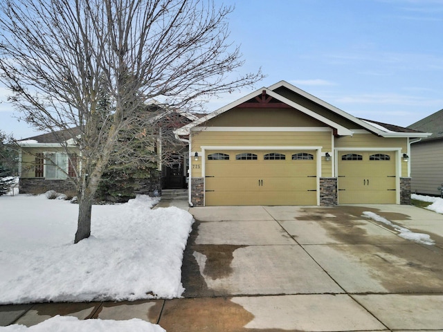 craftsman house with stone siding, an attached garage, and driveway