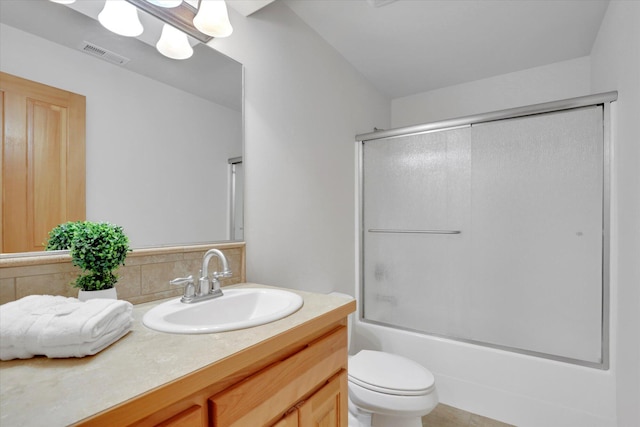 bathroom featuring visible vents, tasteful backsplash, vanity, bath / shower combo with glass door, and toilet