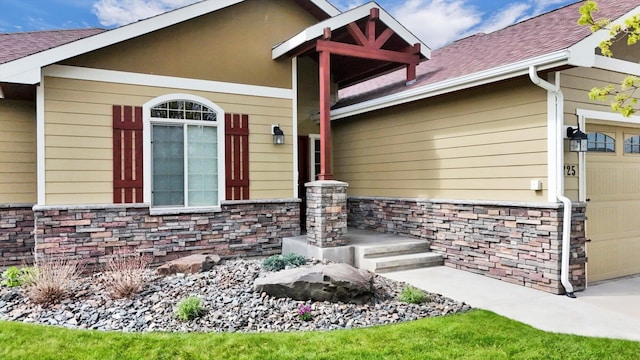 view of front of home featuring an attached garage, roof with shingles, and stone siding