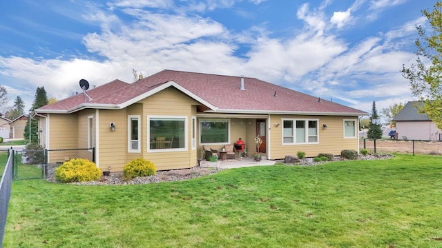 rear view of property featuring a patio area, fence, and a yard