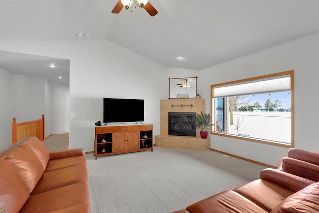 carpeted living area with baseboards, a ceiling fan, a glass covered fireplace, vaulted ceiling, and recessed lighting