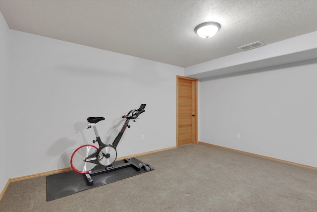 workout room featuring a textured ceiling, baseboards, visible vents, and carpet