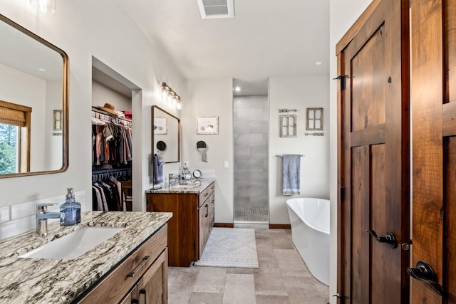 31914 N Zander Ln, Chattaroy, WA 99003 - full bath featuring two vanities, a stall shower, a freestanding tub, a spacious closet, and baseboards