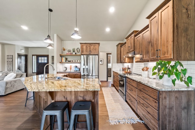 31914 N Zander Ln, Chattaroy, WA 99003 - kitchen featuring stainless steel appliances, a sink, open shelves, under cabinet range hood, and a breakfast bar area