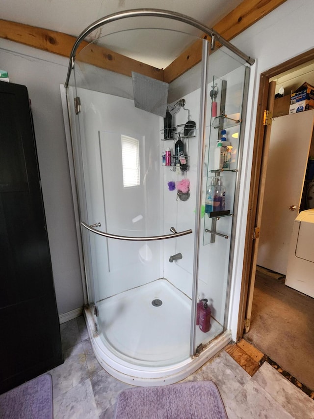 bathroom with washer / dryer and a shower with door