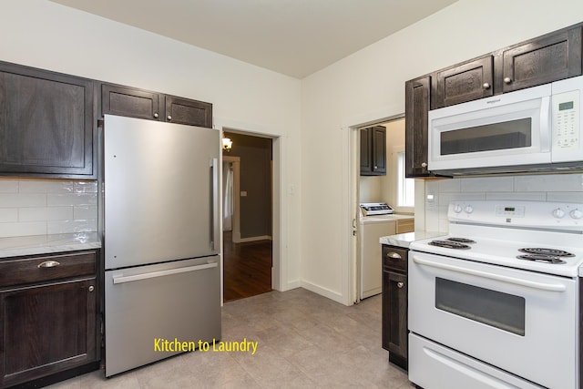 kitchen with dark brown cabinetry, white appliances, tasteful backsplash, and washer and dryer