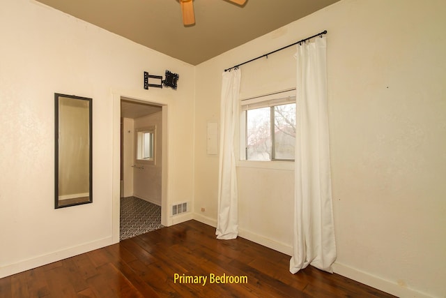 spare room with dark wood-type flooring and ceiling fan