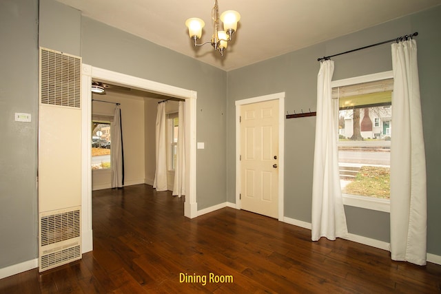 entryway with dark wood-type flooring and a chandelier