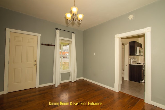 interior space featuring an inviting chandelier and dark wood-type flooring