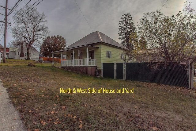 view of side of property featuring a porch and a lawn