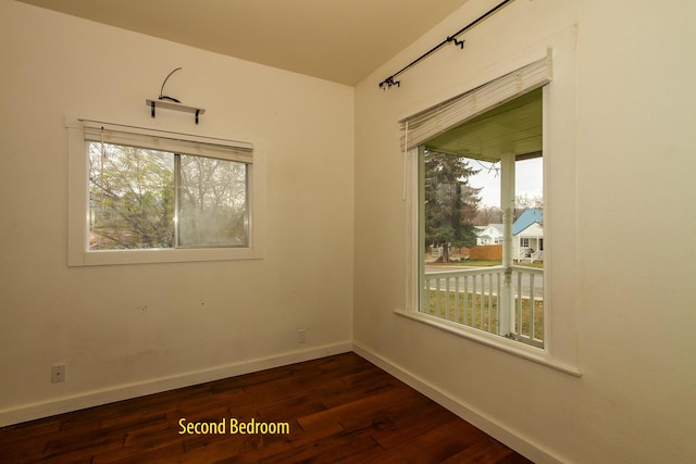 unfurnished room with dark wood-type flooring