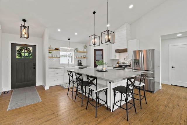 2419 Indian Ridge Rd, Chewelah, WA 99109 - kitchen with appliances with stainless steel finishes, open shelves, a breakfast bar, decorative backsplash, and recessed lighting