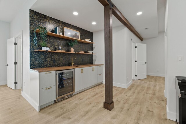2419 Indian Ridge Rd, Chewelah, WA 99109 - indoor wet bar featuring wine cooler, baseboards, light wood finished floors, an accent wall, and wallpapered walls