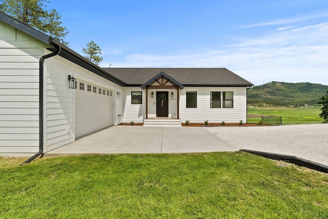 2419 Indian Ridge Rd, Chewelah, WA 99109 - view of front facade featuring a front yard, a garage, driveway, and a mountain view