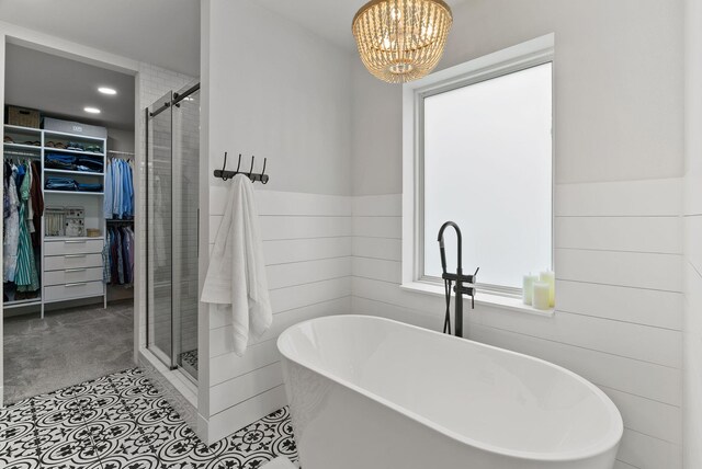 2419 Indian Ridge Rd, Chewelah, WA 99109 - bathroom with a spacious closet, a shower stall, a freestanding tub, a chandelier, and wainscoting