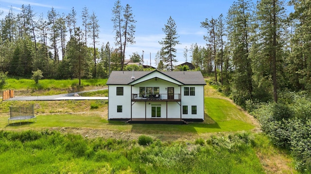 2419 Indian Ridge Rd, Chewelah, WA 99109 - back of house featuring a lawn, a trampoline, and a wooden deck