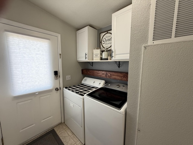 laundry room featuring cabinet space, washing machine and dryer, and light tile patterned flooring