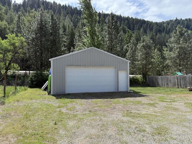 detached garage featuring a forest view