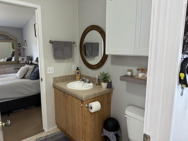 ensuite bathroom featuring vanity and toilet